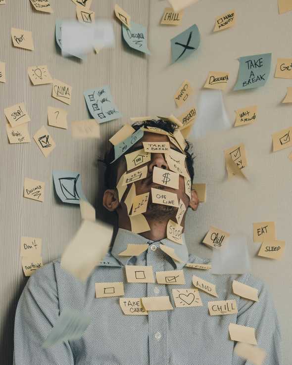 Man overloaded with post-it notes
