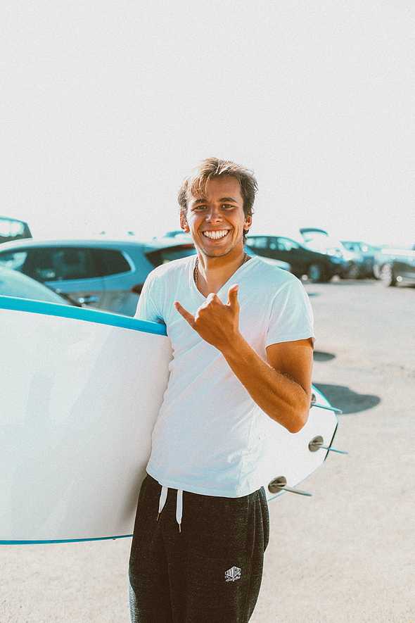 Grinning man carrying white surfboard, Photo by Daria Shevtsova from Pexels